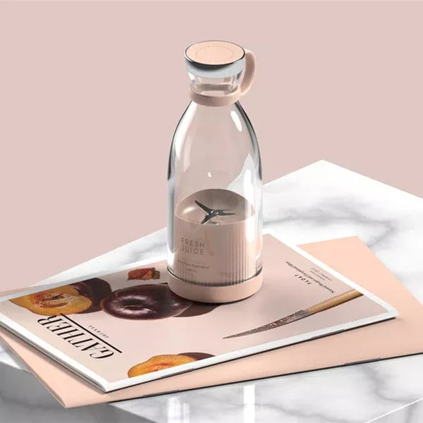 Clear glass bottle with a pink base on a magazine with a pink background