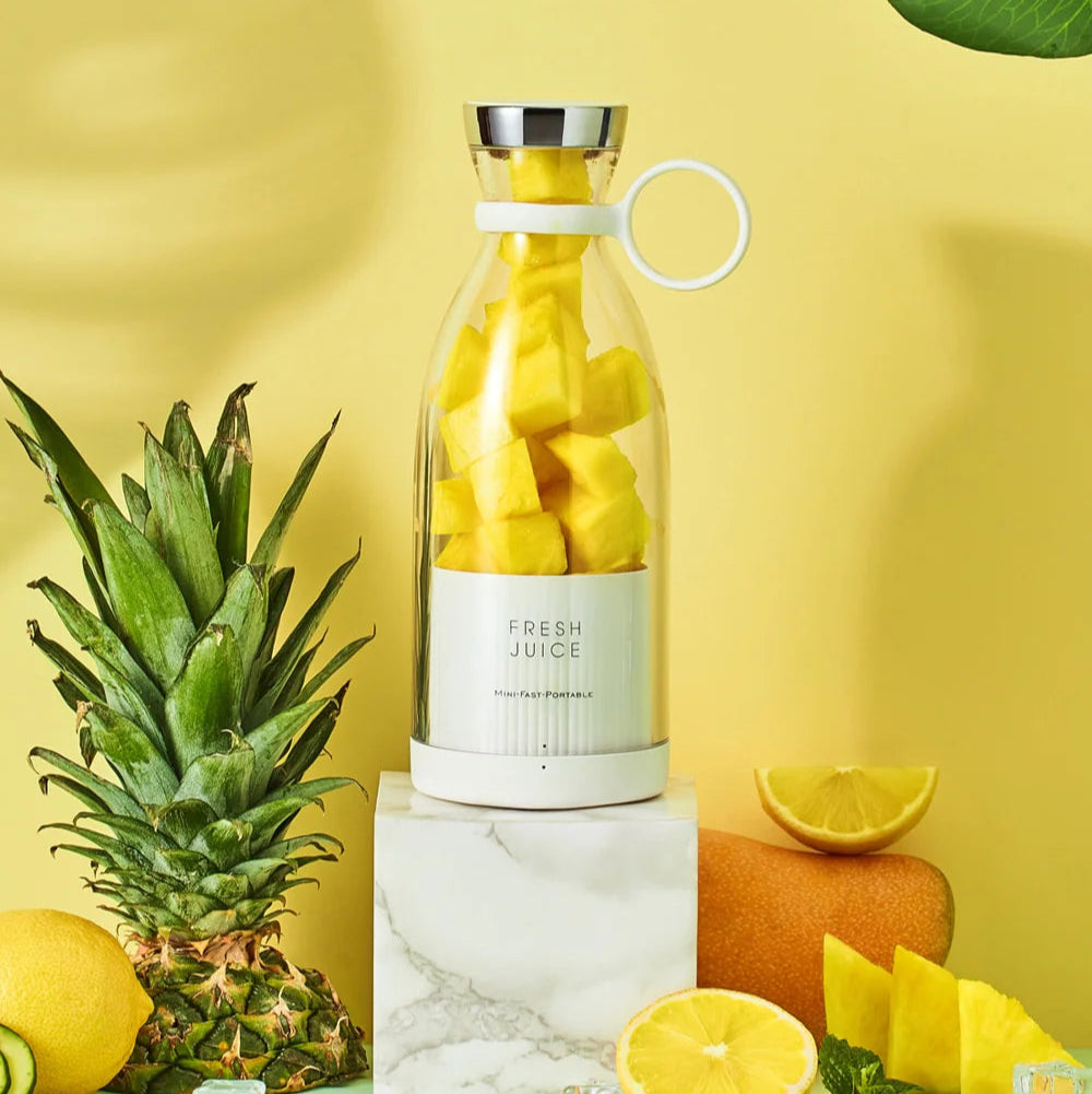 Portable mini blender with fruits on a yellow background