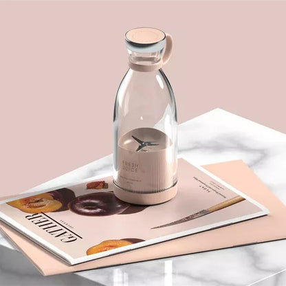 Clear glass bottle with a pink base on a magazine with a pink background